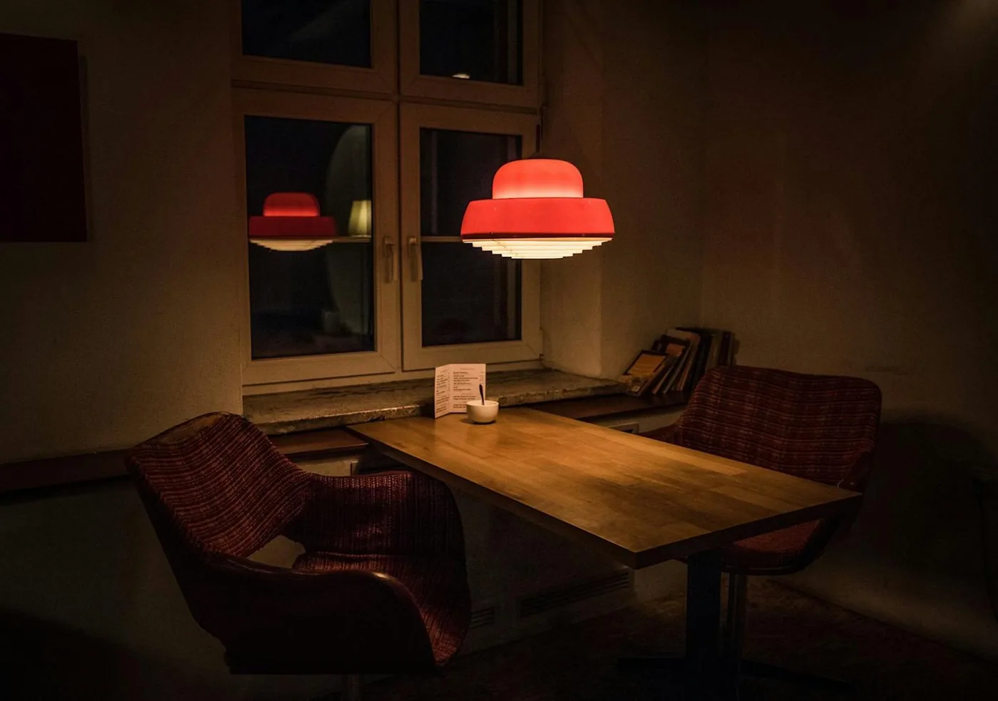 Warm gelicht poker-salon in Maastricht — kaarsen op de tafels, lederen stoelen, donker hout